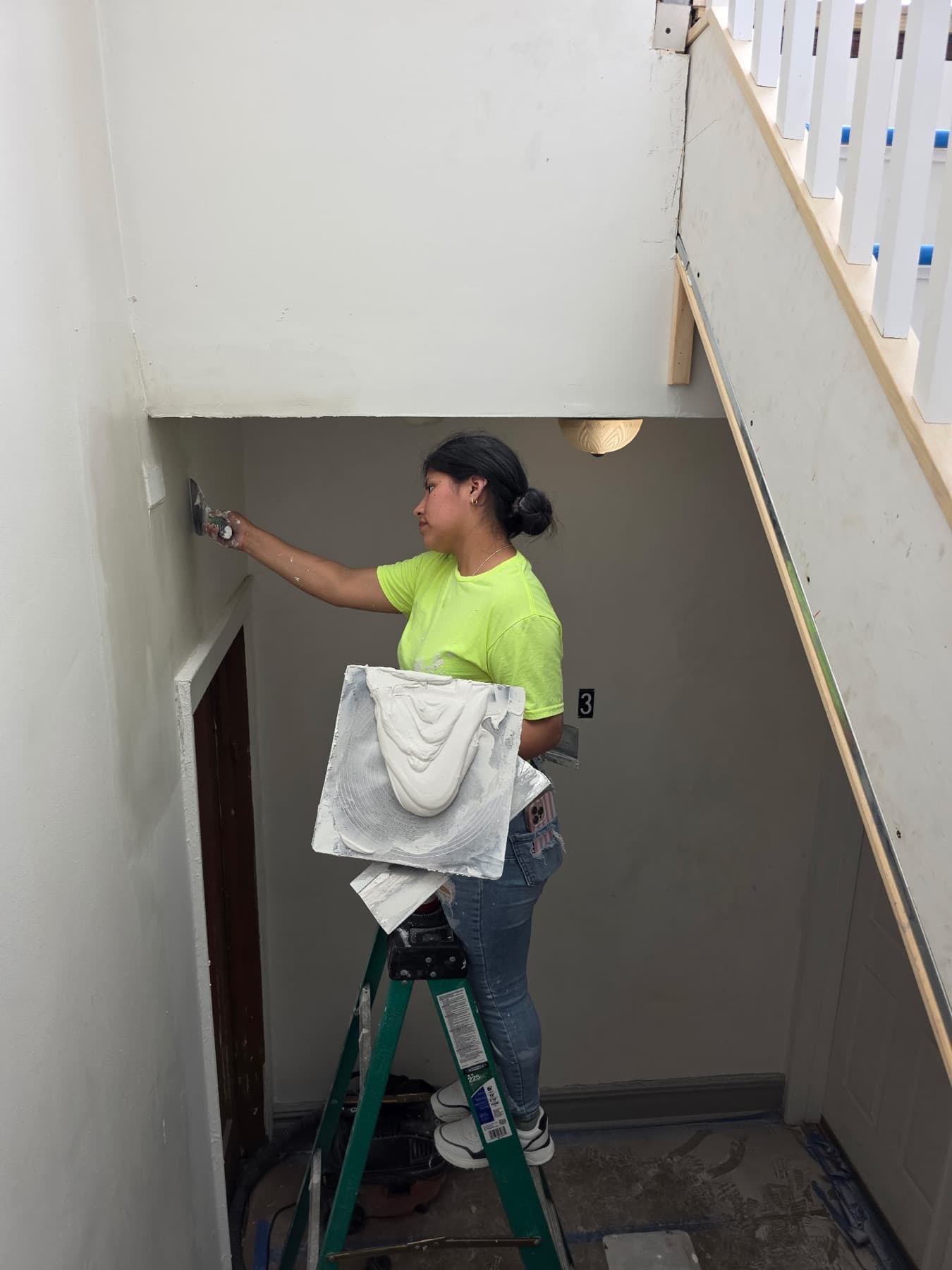 BRM crew member applying finish from a ladder